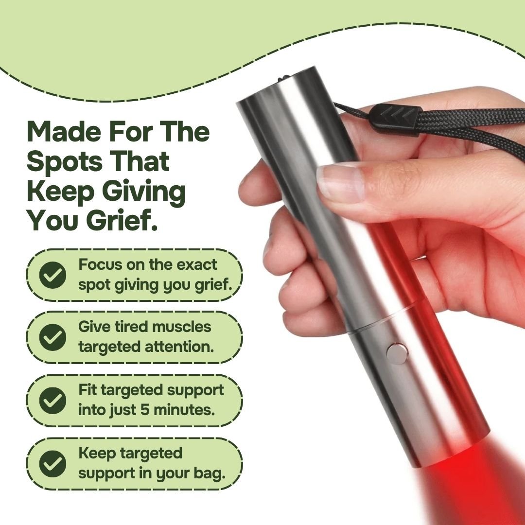 Hand holding silver red light therapy torch with wrist strap, red beam on, for targeted spot use