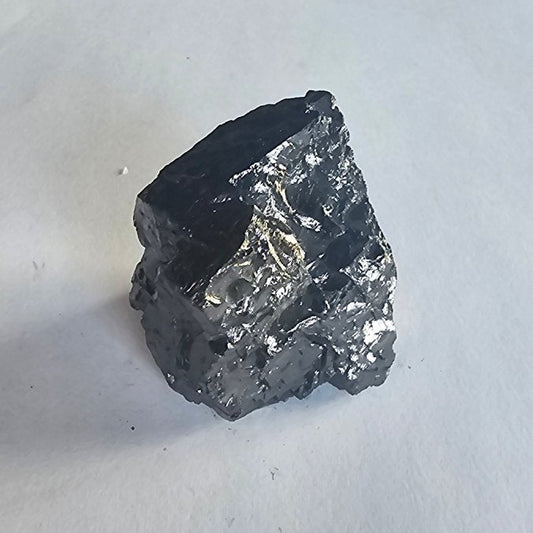Elite shungite nugget #8, 40.6g: silvery faceted chunk standing on white paper, labelled desk and nuggets behind