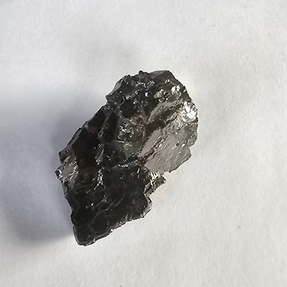 Mount Noshaq shungite crystal, 12g one-piece nugget: upright nugget with bright pewter-silver facets, narrowing at the base