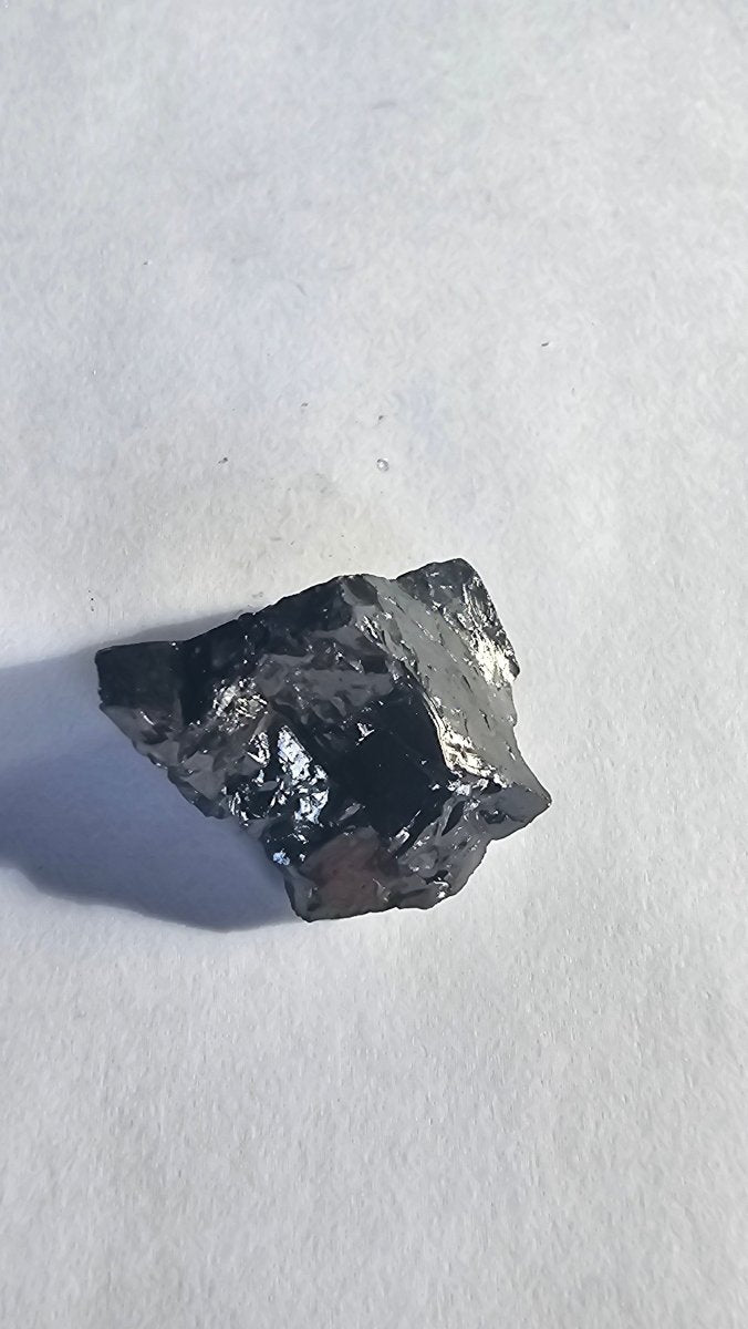 Malte Brun shungite crystal, 11g one-piece nugget: small chunky nugget with bright silvery facets on one side